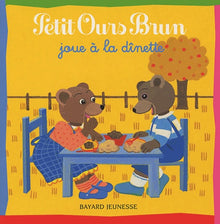 Petit ours brun joue à la dînette